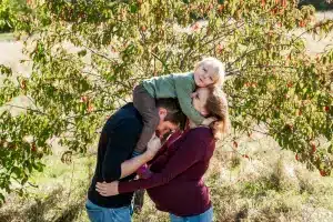 Kind sitzt beim Familienshooting auf den Schultern seiner Eltern